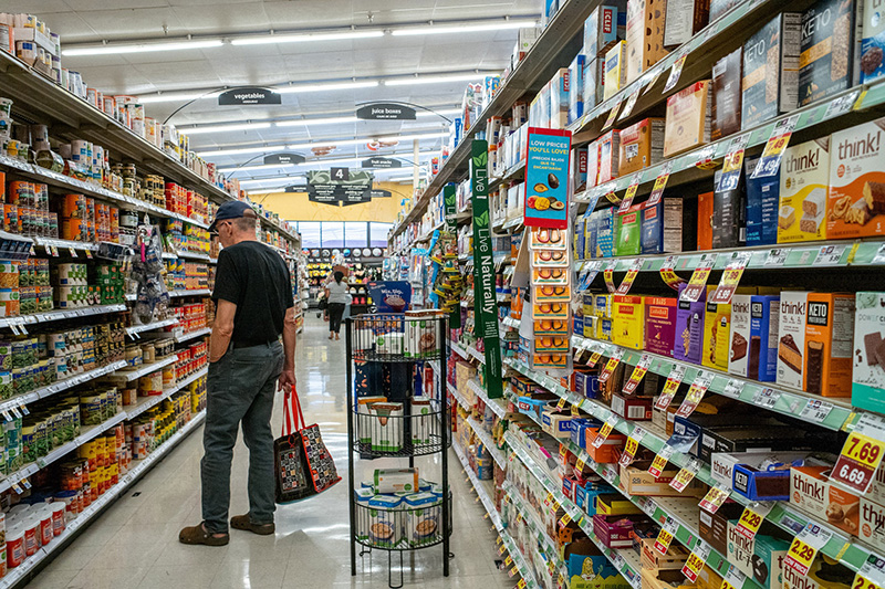 grocery aisle with people shopping